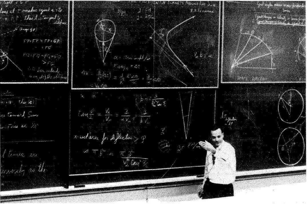 Richard Feynman speaking beside a blackboard during the 1964 Caltech planetary-motion lecture.